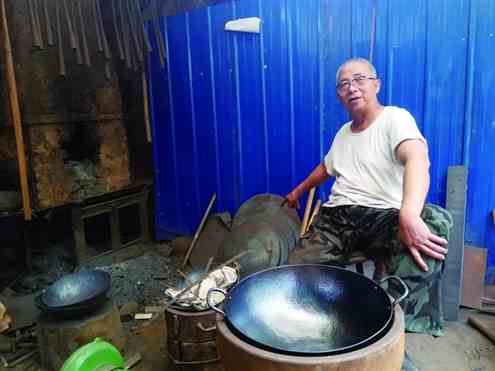 老铁匠牛祺圣在介绍他最近打造的一口大铁锅